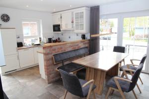 a kitchen with a wooden table and chairs at Stüürmanns Huus in Hilgenriedersiel