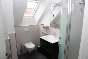 a small bathroom with a sink and a toilet at Stüürmanns Huus in Hilgenriedersiel +21 photos