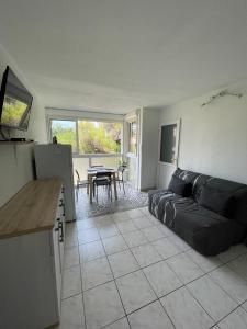 sala de estar con sofá negro y mesa en Appartement familial à 50m de la plage - Narbonne Plage - 4LBM492, en Mosset