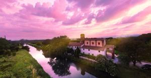 a building on the side of a river at -- Il Casale Toscano -- 1700mt dalla Torre di Pisa, ONLY RENTS ROOMS WITHOUT BREAKFAST, FREE PARKING, POSSIBILITÀ DI SELF CHECK-IN DALLE 15 in Pisa