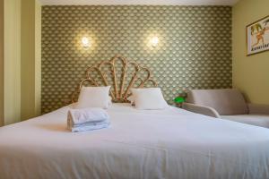 1 cama blanca grande con 2 toallas en Hôtel Cosmopolitain, en Biarritz