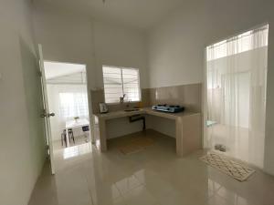 a white bathroom with a desk and a window at Cosy little home near to the town in Pasir Puteh