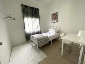 a small bedroom with a bed and a table at Cosy little home near to the town in Pasir Puteh