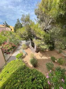 un jardín con flores y árboles y un camino en Appartement familial à 50m de la plage - Narbonne Plage - 4LBM492, en Mosset