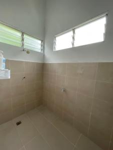 a bathroom with a window and a large shower at Cosy little home near to the town in Pasir Puteh