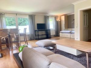 a living room with a couch and a table at Ruhiges Landhaus am Wald mit Garten mit Schlafzimmer und Schlafnische in Aurich