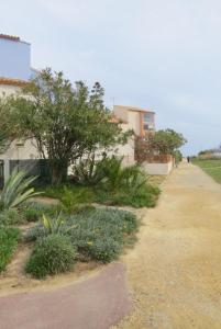 una pasarela junto a un edificio con árboles y plantas en Appartement familial à 50m de la plage - Narbonne Plage - 4LBM492, en Mosset