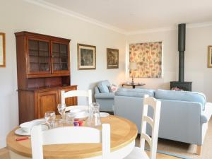 sala de estar con mesa y sofá en Flagstone Cottage en Cheltenham