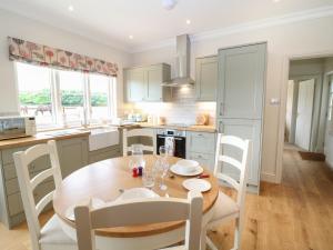 a kitchen with a wooden table and a table and chairs at Flagstone Cottage in Cheltenham +7 photos