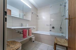 a bathroom with a sink and a bath tub at Casa Dschember, Wohnung 11, 1-6 Personen in Arosa +13 photos