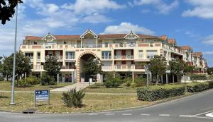 un gran edificio al lado de una calle en The Barbots apartment en Gujan-Mestras