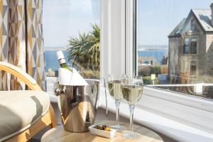 a table with two glasses of wine and a window at The Olive Branch in St Ives