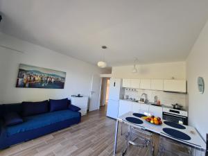 a living room with a blue couch and a kitchen at Vila Elena in Prigradica