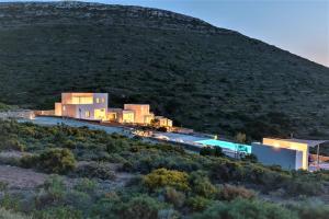 a building on a hill with a mountain in the background at Noble 7 Suites - Adults Only - Onar Hotels Collection in Parikia