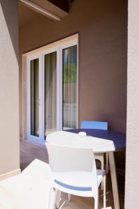 a white table and chairs in a room with a window at Domina Apartments in Monopoli