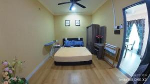 a bedroom with a bed and a ceiling fan at SS homestay manjung in Seri Manjung