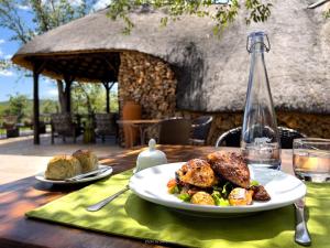 a table with a plate of food and a bottle of water at Ongava Tented Camp in Okaukuejo