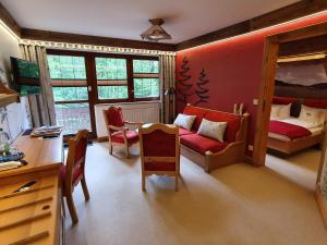 a room with a bedroom with a bed and a desk at Hotel und Restaurant Köhlerhütte - Fürstenbrunn in Beierfeld
