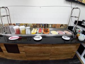 a counter with many different types of donuts on it at Pousada do Vladimir in Boracéia