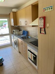 a kitchen with a sink and a stove top oven at T1 Apartment Cabanas in Cabanas de Tavira