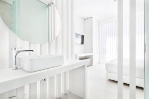 a white bathroom with a sink and a mirror at Vila Maria Hotel - Adults Only in Albufeira