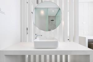 a white bathroom with a sink and a mirror at Vila Maria Hotel - Adults Only in Albufeira
