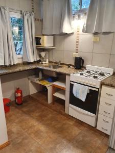 una cocina con estufa y fregadero en Naranja, en Rosario