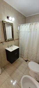 a bathroom with a sink and a toilet and a shower at Navarro Departamentos Temporarios in Navarro