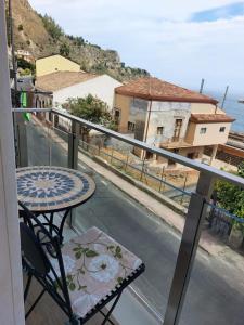 a balcony with a table and a view of a street at Case Pagano Mare in Taormina