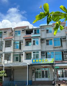 un edificio de apartamentos con un cartel delante en Happy Homestay, en Budai