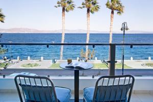 a view of the ocean from a balcony with palm trees at KoSea Boutique Hotel in Kos