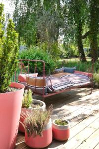 a metal bed sitting on a deck with potted plants at L'Orme Blanchet Spa & Piscine, petit-déjeuner inclus in Chambon-la-Forêt