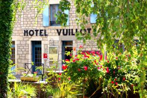 a hotel yard with flowers in front of a building at Logis Hôtel Restaurant Vuillot in Cuiseaux