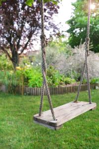 a wooden swing in a yard with grass at L'Orme Blanchet Spa & Piscine, petit-déjeuner inclus in Chambon-la-Forêt