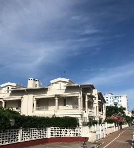 um edifício branco com uma cerca em frente em B&B El Dorado em Lido di Pomposa