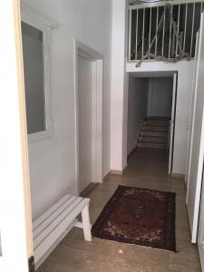 un pasillo con un banco y una alfombra y escaleras en Sopravento Apartments - Margherita di Savoia en Margherita di Savoia