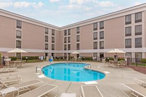 a pool in front of a hotel with chairs and tables at Comfort Inn University Durham - Chapel Hill in Durham