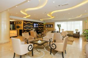 a lobby of a hotel with chairs and a table at Ivory Grand Hotel Apartments in Dubai