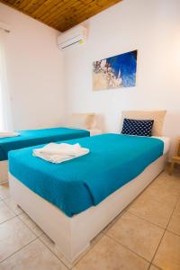 a bedroom with a blue and white bed in a room at Serenity Apartments in Agios Georgios