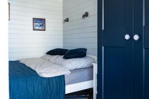 een kleine kamer met een bed met blauwe kussens erop bij Domki U Rybaka in Łeba