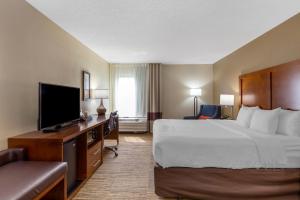 a hotel room with a bed and a flat screen tv at Comfort Inn University Durham - Chapel Hill in Durham