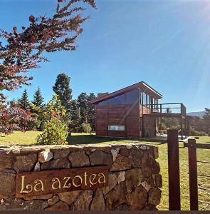una casa con una valla de piedra y una pared de piedra en La Azotea cabañas & suites en La Cumbrecita