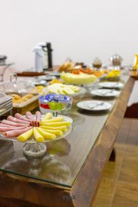 a long table with many plates of food on it at Pousada Água Eterna - Próximo ao Museu de Cera, Hot Beach e Thermas dos Laranjais - By UP Hotel in Olímpia