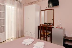 a bedroom with a table and a mirror and a desk at Hotel Villa Plaza in Spetses