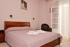 a bedroom with a bed with towels on it at Hotel Villa Plaza in Spetses