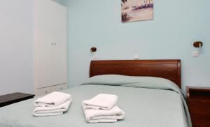 a bedroom with a bed with two towels on it at Hotel Villa Plaza in Spetses