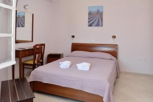 a bedroom with a bed with two towels on it at Hotel Villa Plaza in Spetses