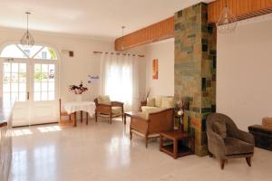 a living room with a table and chairs and a fireplace at Hotel Villa Plaza in Spetses