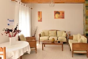 a living room with a couch and chairs and a table at Hotel Villa Plaza in Spetses