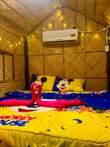 a bed in a tent with two flamingos on it at เดอะกระต็อบ By The Mountain Ozone บ้านโอโซนขุนเขาแก่งกระจาน in Ban Song Phi Nong